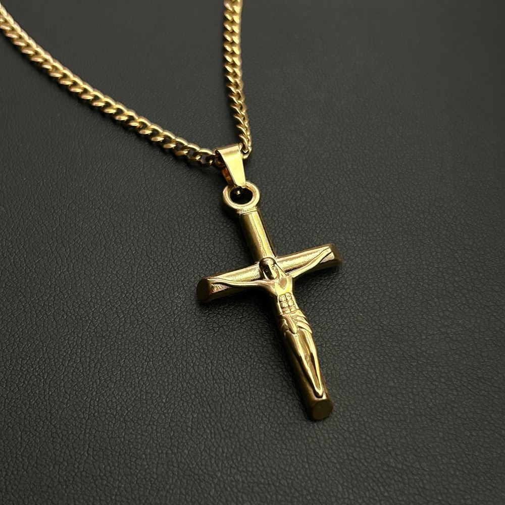 The crucifix pendant on its own chain, on black leather
