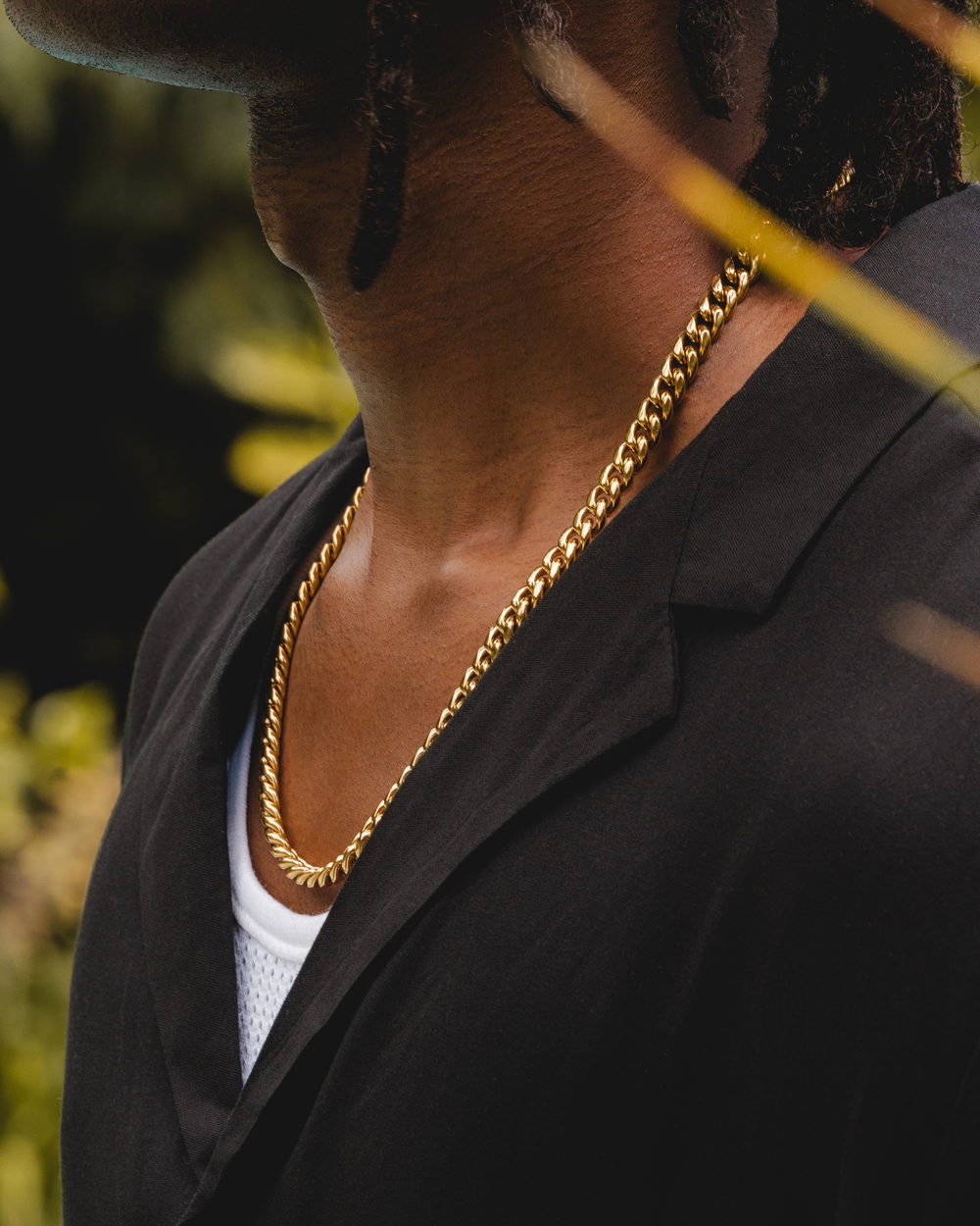 The 8mm Cuban link worn at the collar over a black shirt