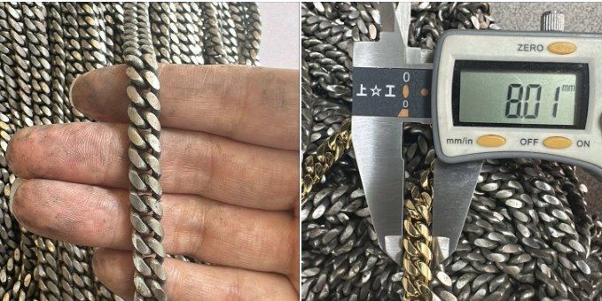 A digital caliper closed on a finished 8 mm Cuban link chain, reading 8.01 millimetres, on a pile of raw chains
